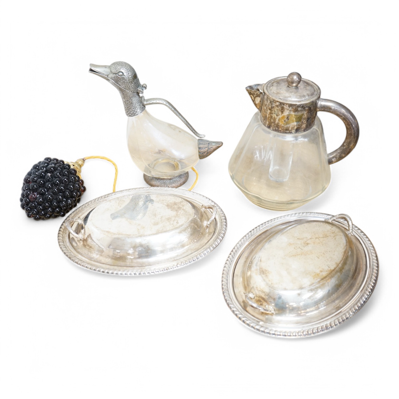 Silver plated ware to include a plated novelty duck decanter and two entree dishes and covers. Condition - fair